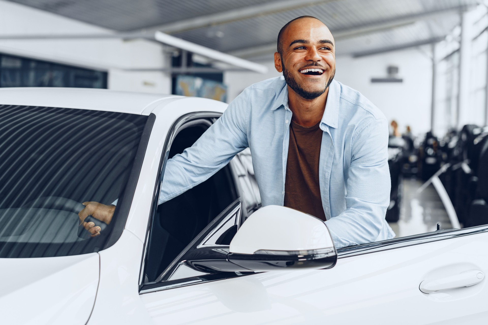 Portrait of a handsome happy African American man sitting in his newly bought car